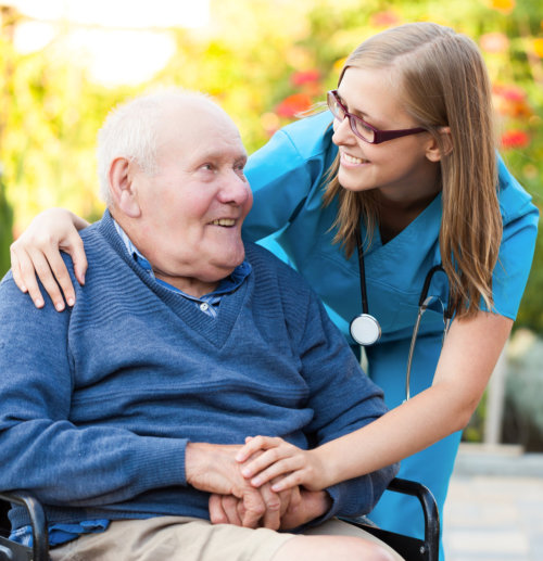 elderly  man smiling to a caregiver